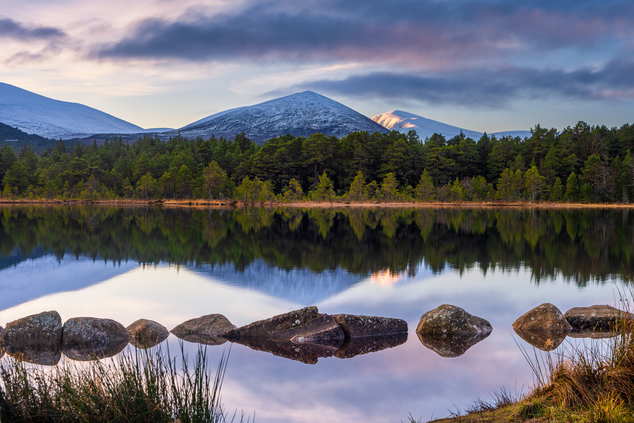 Image description: Winter reflections of the snow capped mountains of the Cairngorms in Scotland