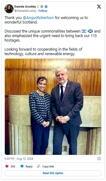 A tweet by Daniela Grudsky shows her standing next to Angus Robertson in front of a wood-panelled wall. Grudsky is wearing a patterned black-and-white top, while Robertson is in a dark suit and tie. The tweet thanks Robertson for welcoming her to Scotland, mentions discussing commonalities between Israel and Scotland, calls for the return of 115 hostages, and expresses interest in cooperation on technology, culture, and renewable energy.