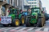 Article: Are conspiracy groups trying to hijack farmers’ protests? Image description: Tractors parked and road traffic at a s