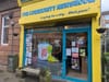 article headline: Ten years on, The Ferret is still digging — and looking ahead alt text: A bright yellow shopfront with blue